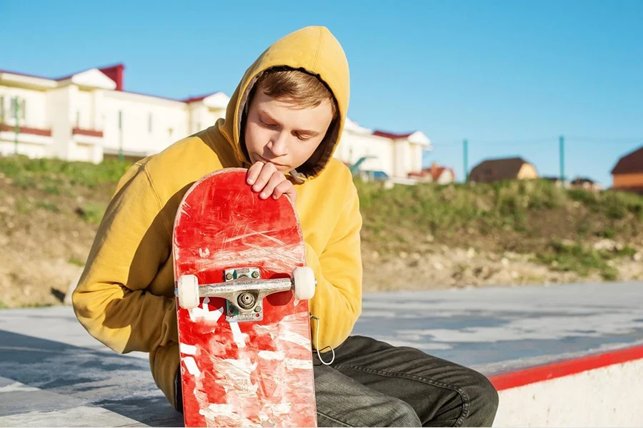 ein Teenager in einem gelben, übergroßen Kapuzenpullover