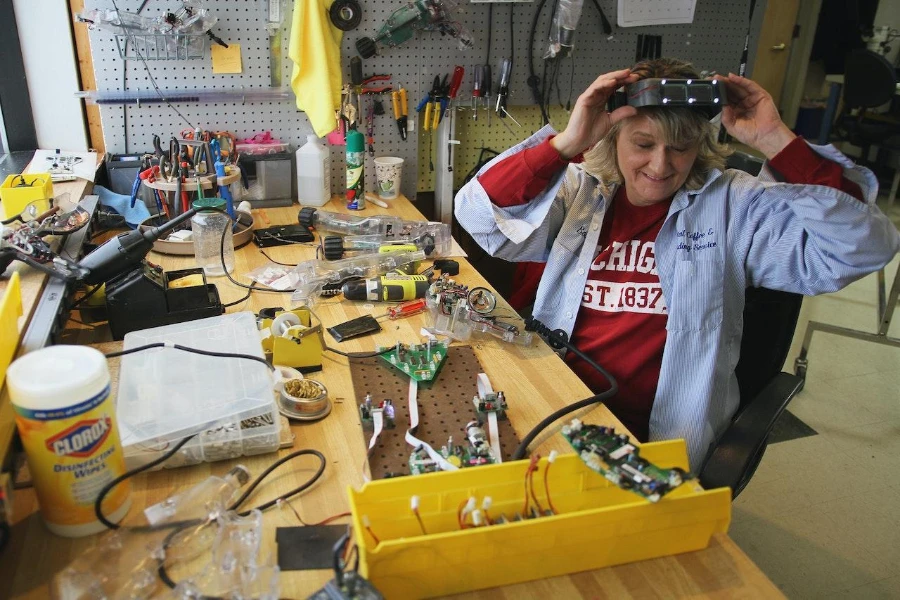 A woman in her workshop using a yellow cable management box
