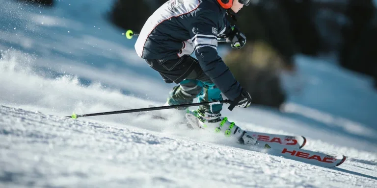 an athlete skiing down a snow slope with multiple accessories