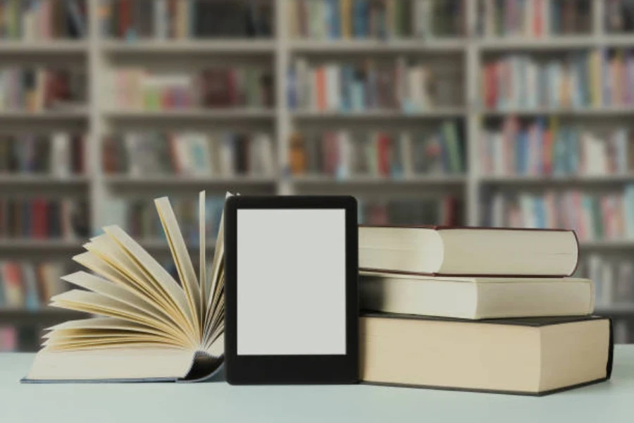 An e-reader placed in between a stack of books