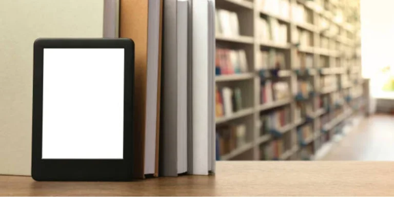 An e-reader placed in front of a stack of books