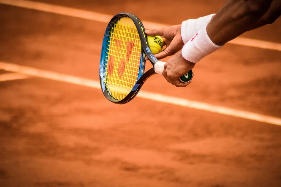 athlete with a ball and racket wearing white sweatbands