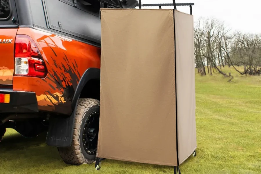 beige awning shower tent attached to side of vehicle