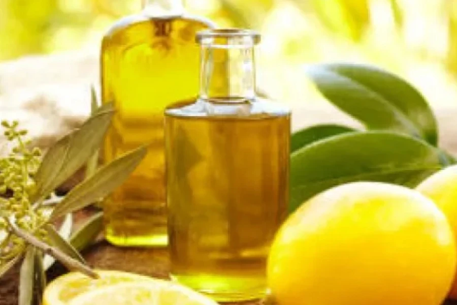 Bottles of lemon essential oil and lemon fruits around them