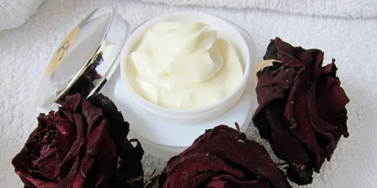 cream in a jar with flowers spread around it