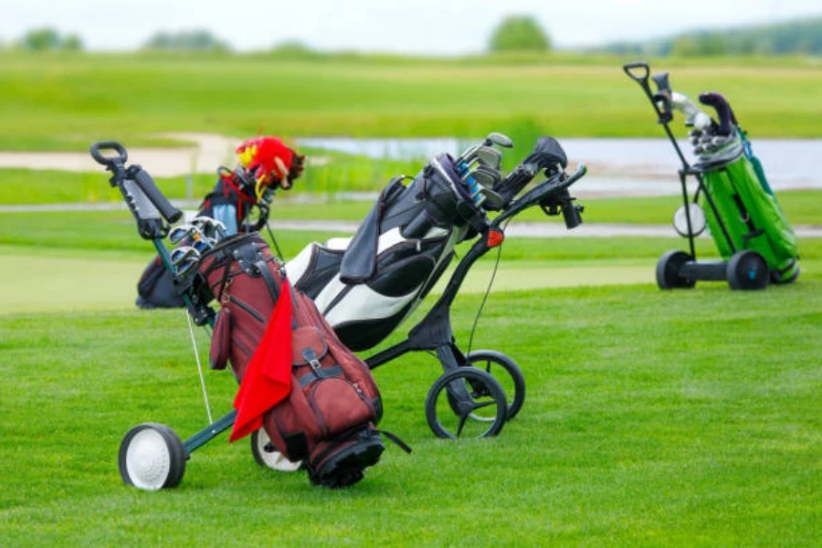 Troli golf yang berbeda terletak di rumput di lapangan golf