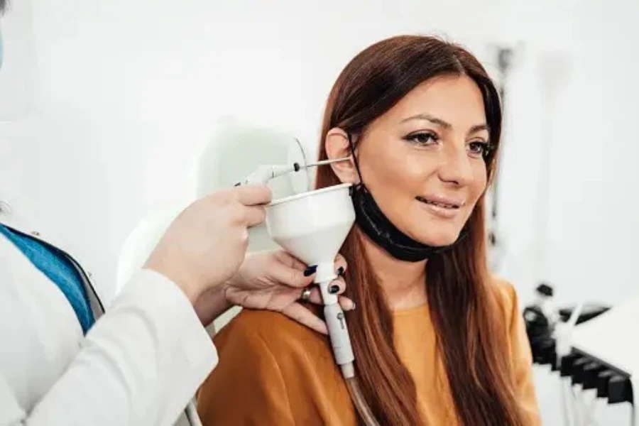 Médecin insérant une sonde de micro-aspiration dans l'oreille d'un patient