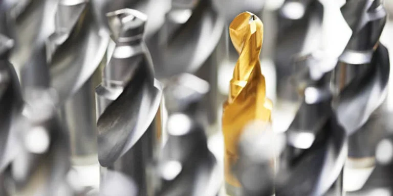 Gold-coated drill bit in a pile of drill bits