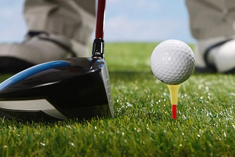 Ayarlanabilir golf topluğu üzerinde oturan golfçü topu sıraya koyuyor