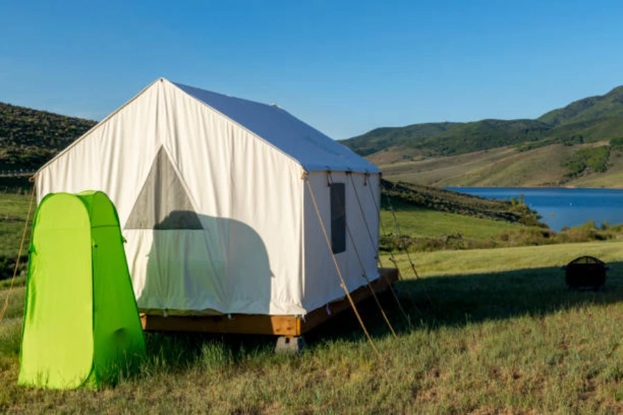 green pop up shower tent next to large white tent