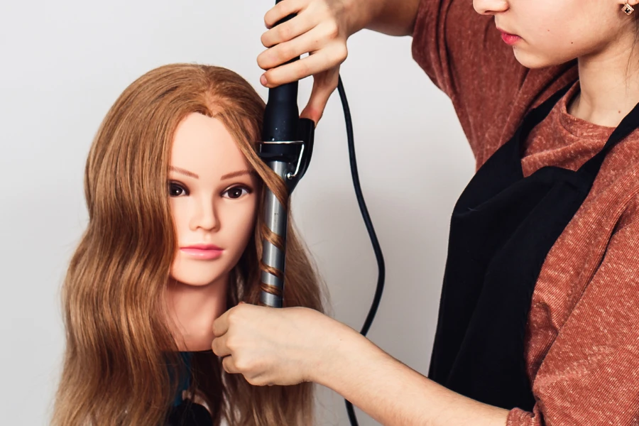 hairstylist styling a wig on a mannequin head