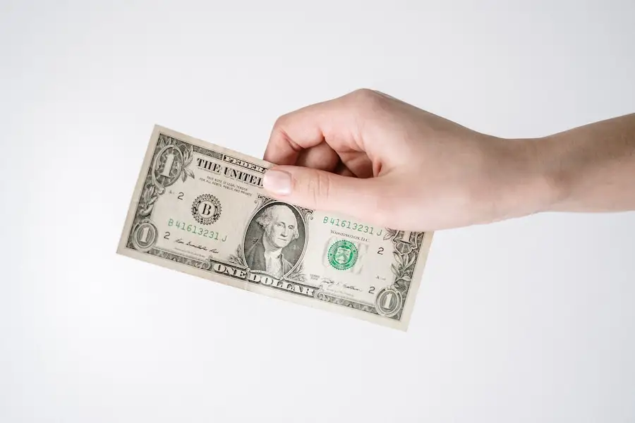 Hand holding a one dollar bill