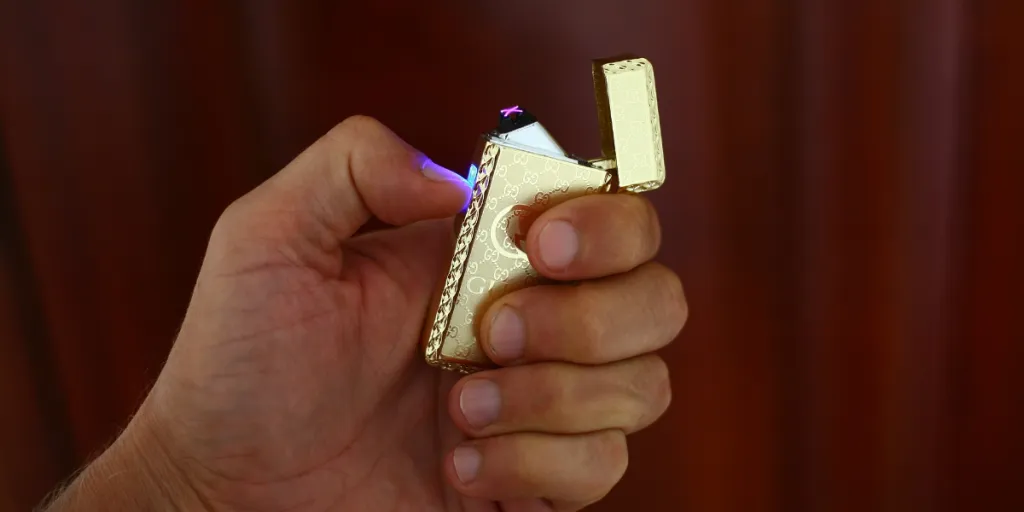 hand holding golden electric lighter