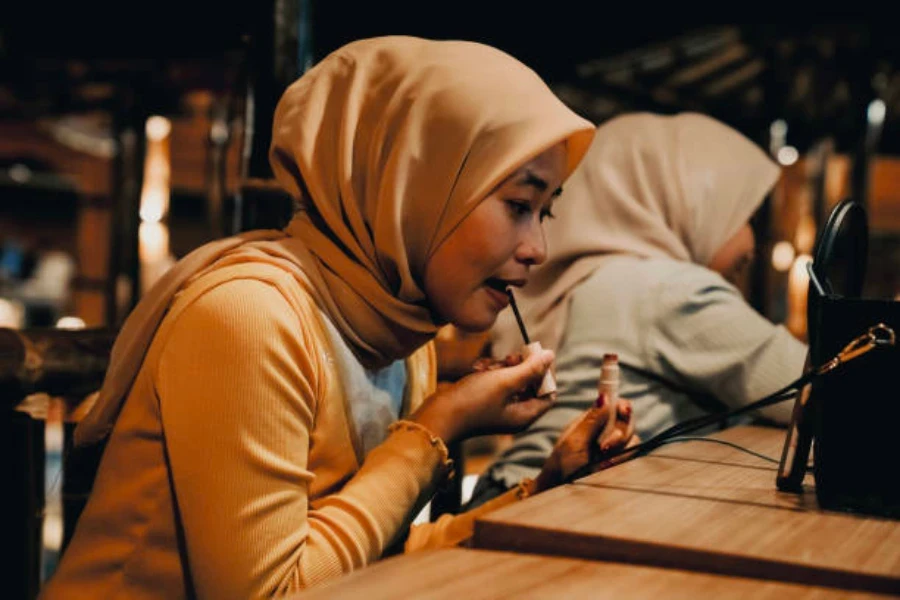 Mujer indonesia aplicando color de labios