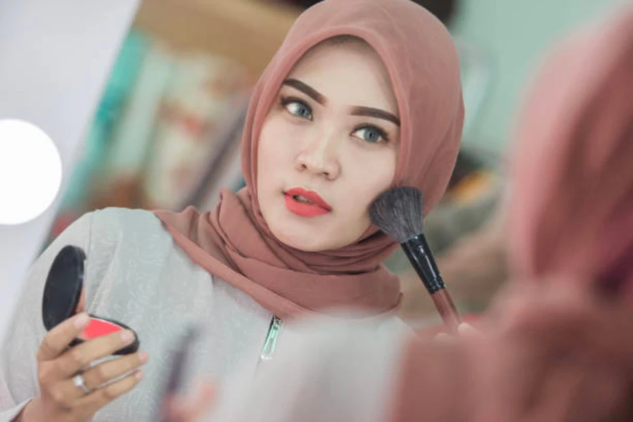 Indonesian women applying blush to her cheeks