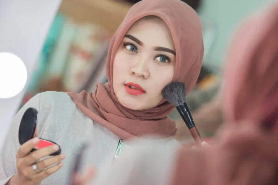 Indonesische Frauen tragen Rouge auf ihre Wangen auf