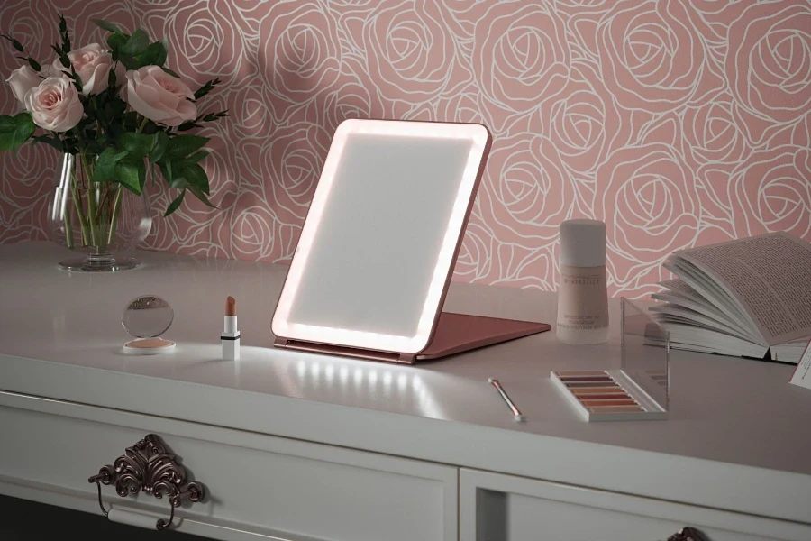 Miroir de maquillage lumineux posé sur une commode blanche à côté du maquillage