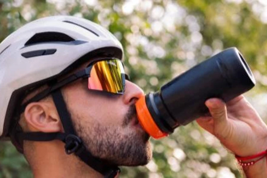 male athlete drinking from a squeeze sports water bottle