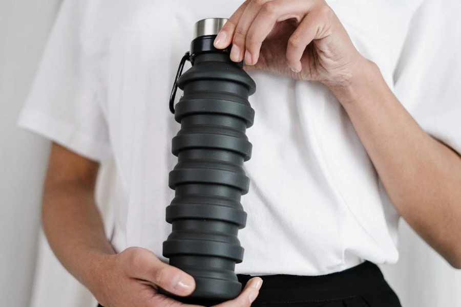 man holding a collapsible sports water bottle