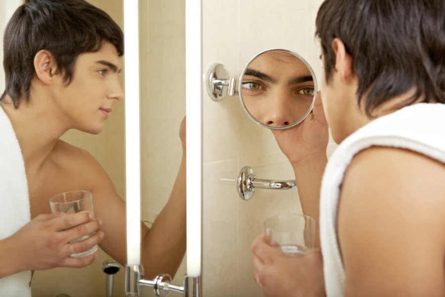 Man looking into a magnifying mirror for grooming