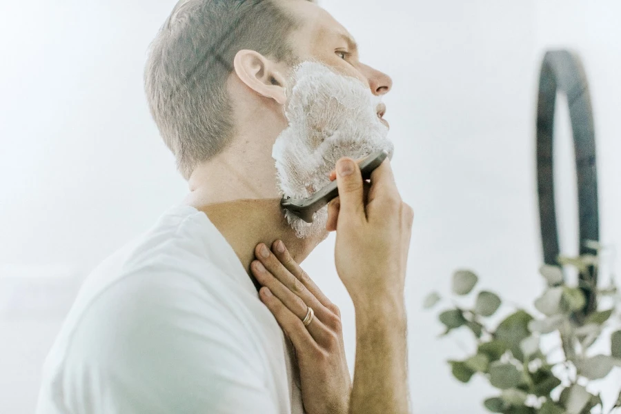 Man shaving his neck while looking in the mirror