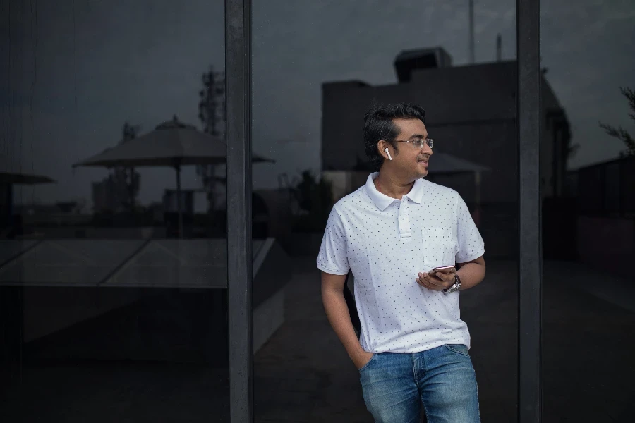 man wearing open earbuds to facilitate a phone call