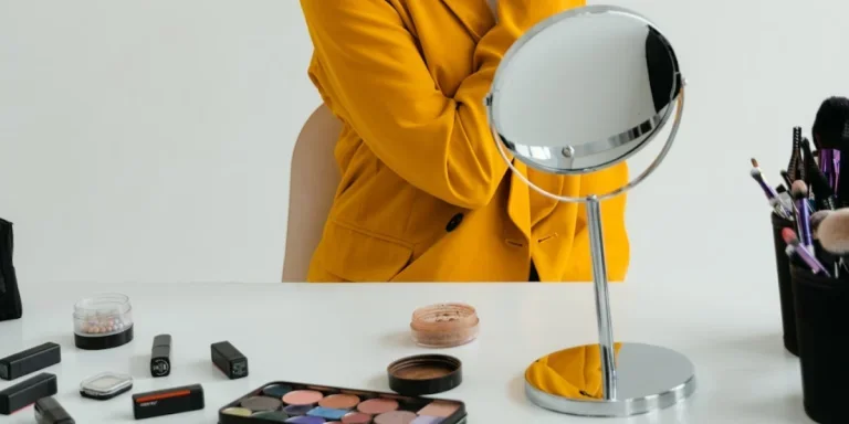 Person, die Make-up in einem runden Spiegel auf einem Ständer aufträgt