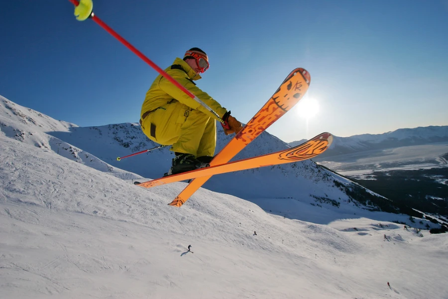 person skiing down the slopes with red ski poles