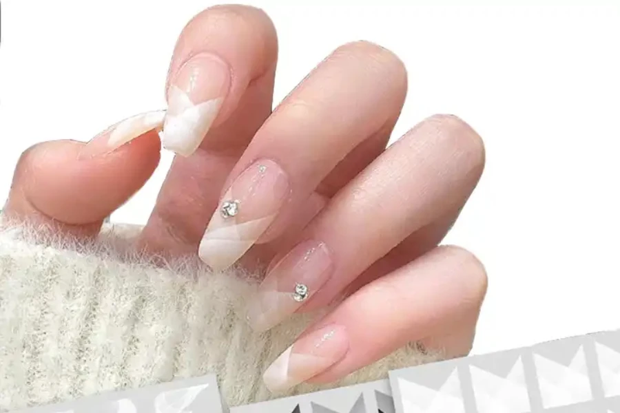 Person with French tip nail stickers and jewels