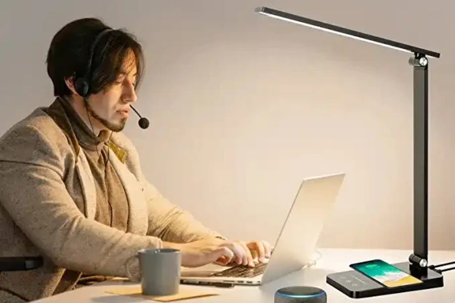 Person working with a lamp on the side of their desk