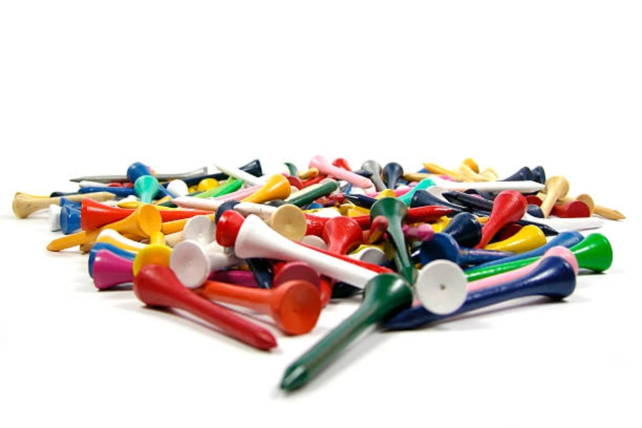 Pile of multi-colored wooden golf tees on white background