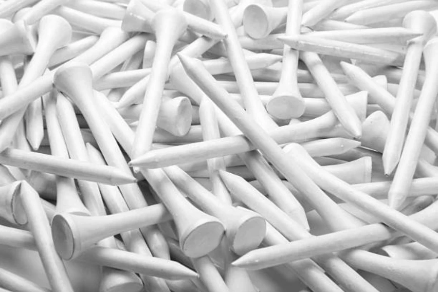 Pile of white wooden golf tees freshly painted