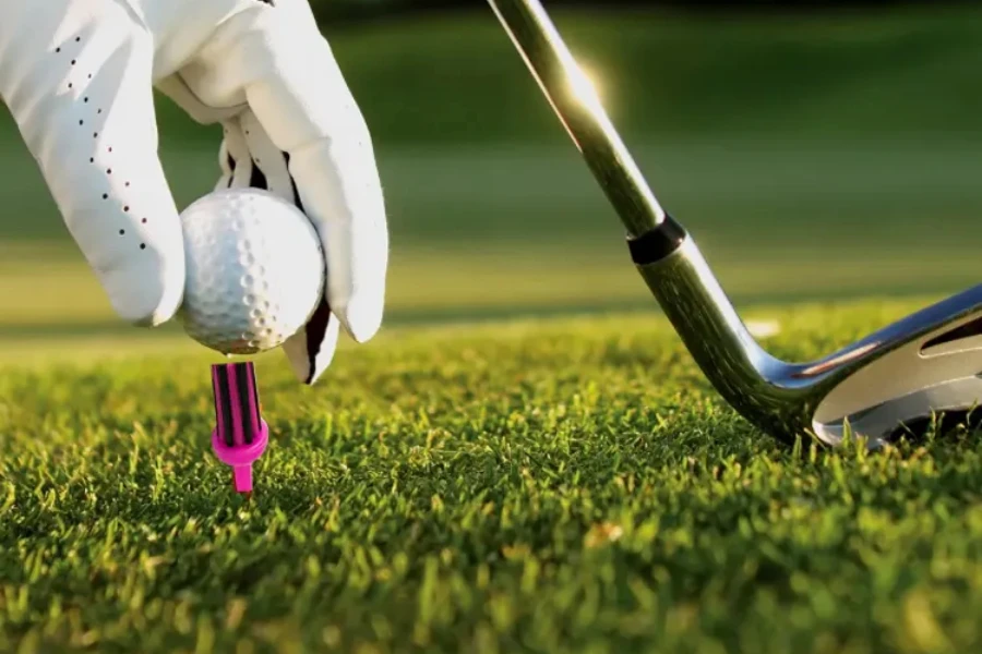 Pink and black brush golf tee sitting in grass