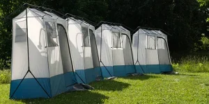 row of pop up shower tents in open park space