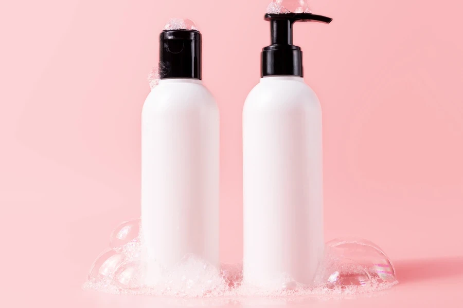 shampoo e condicionador em um fundo rosa