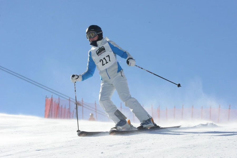 skier in a white outfit using ski poles