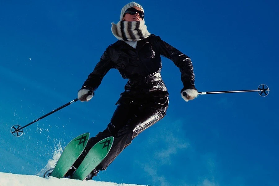 Skifahrer in der Luft, während er Skistöcke hält