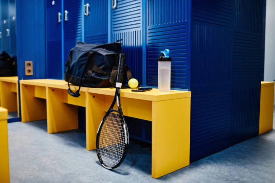 tennis racket and bag on bench inside locker room