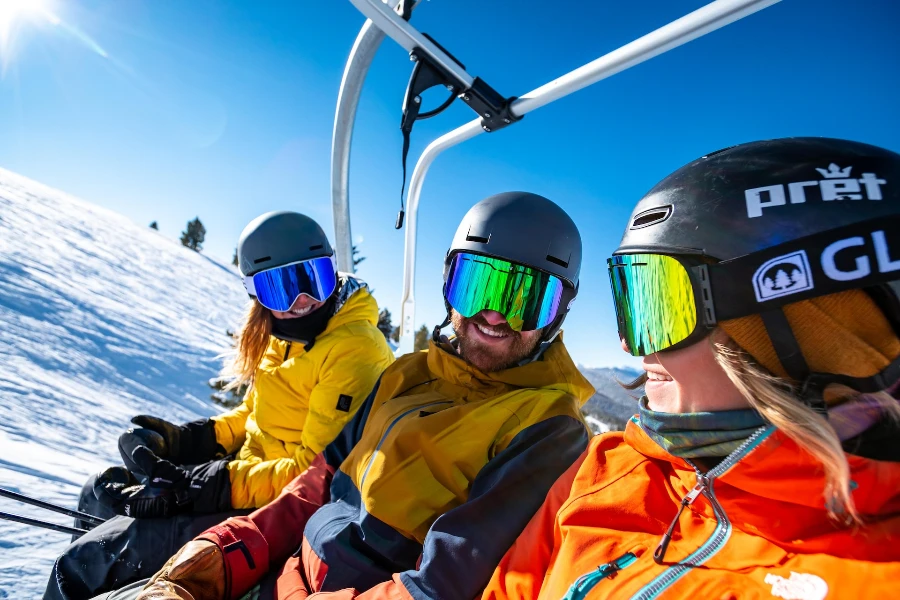 three people wearer full winter sports outfits with ski goggles