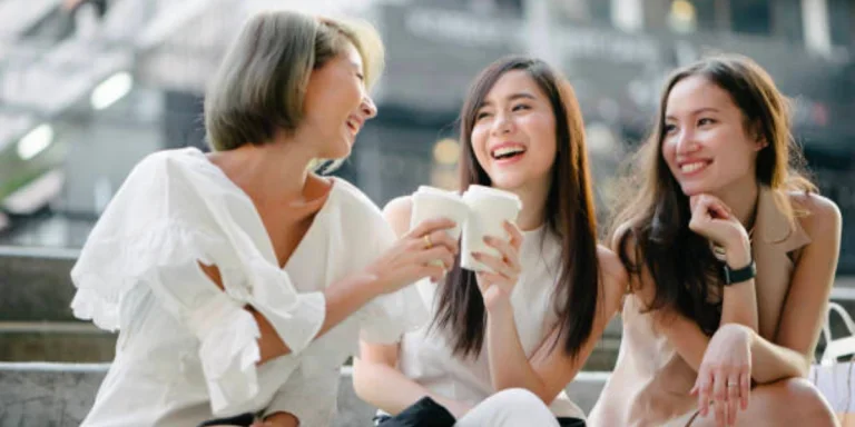 Drei Frauen sitzen zusammen und tragen natürliches Make-up