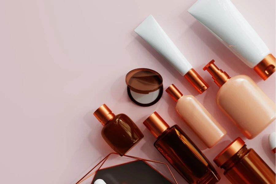 various beauty product bottles lying on a pink background