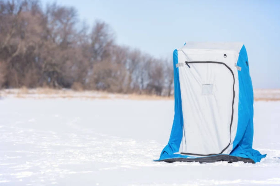 white and blue pop up shower tent sitting in snow