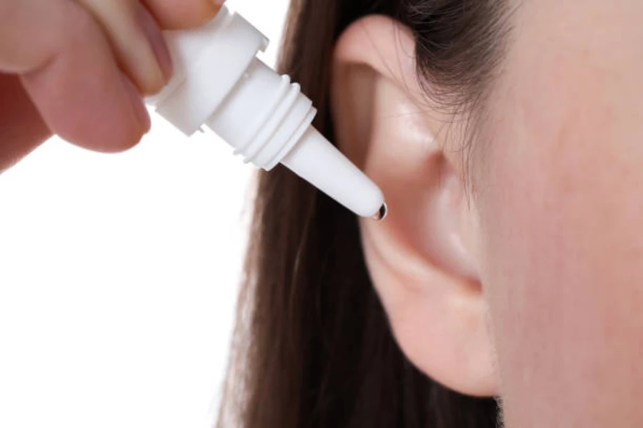 Young lady dripping ear drops into her ear
