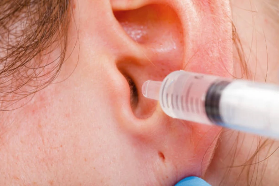 Young woman receiving a medical wash with ear syringe