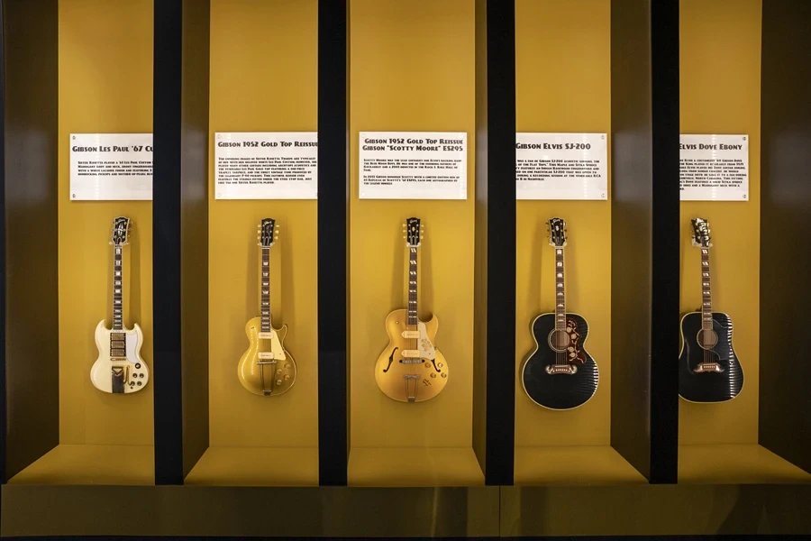 Collection of guitar string instruments hung up at museum