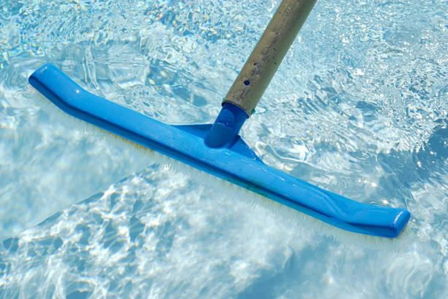 A blue pool brush placed in a pool