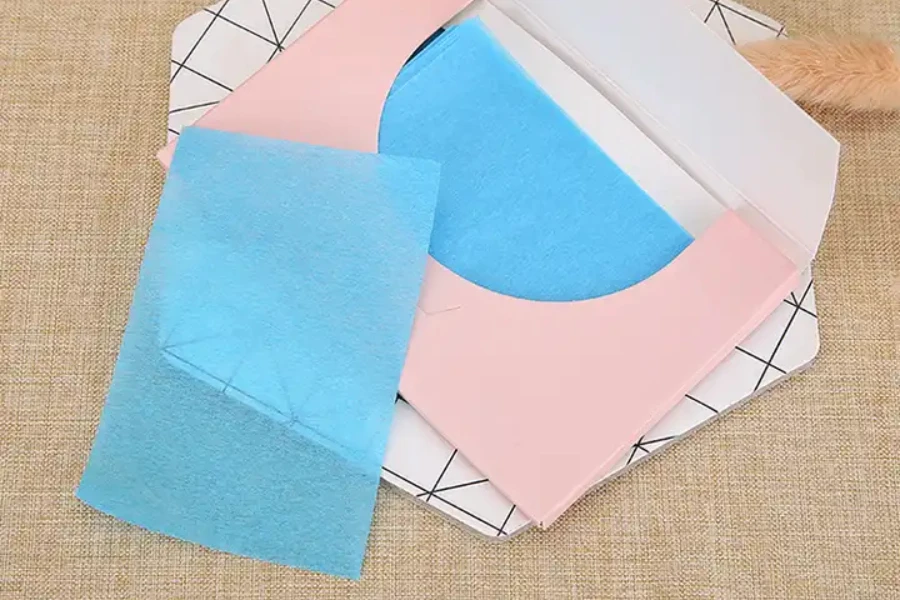 A blue sheet of oil blotting paper on its packaging
