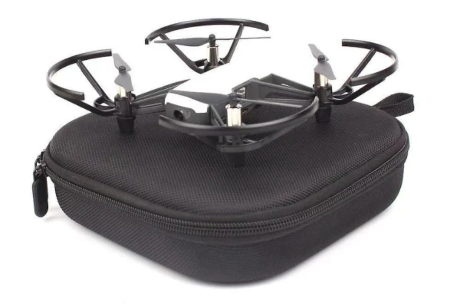 A drone seated on a portable black carrying case
