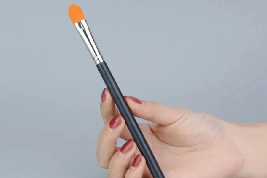 A hand holding a crease brush