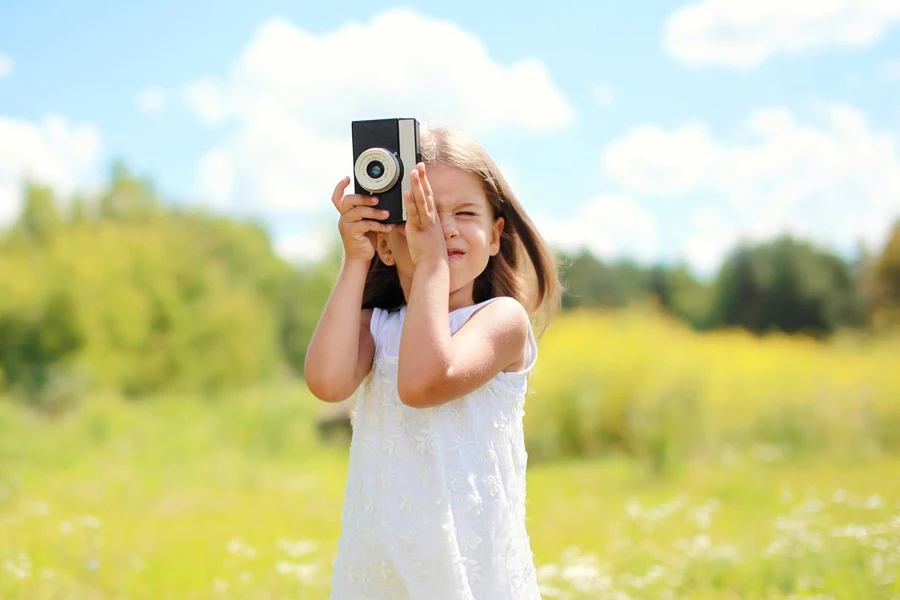 a little girl using a camera